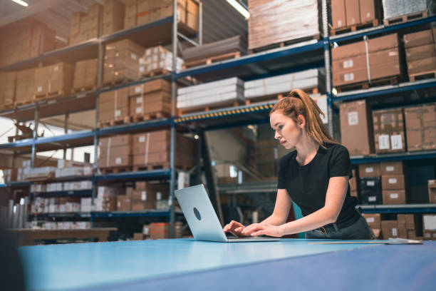 istock Woman using laptop at warehouse 1388821848
