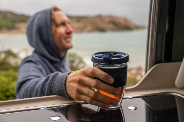 istock Man travelling by camper van having coffee outside his vehicle 1388823782