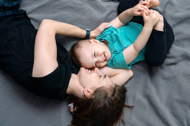 istock Happy smiling mother and son lying on a bed 1388825013