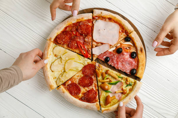 istock Assorted Italian pizza on a white wooden table. 1388825362