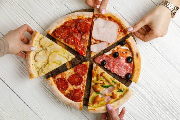 istock Assorted Italian pizza on a white wooden table. 1388825383