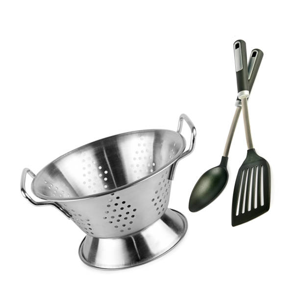 Steel colander and kitchen ladle and spatula isolated on a white.