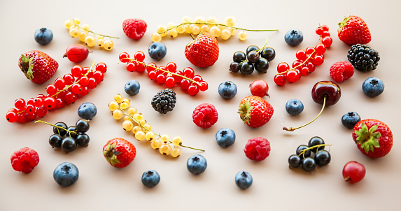 Various ripe fresh summer berries on a neutral background