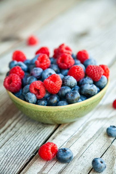 istock Close-up fresh ripe blueberry and raspberry in a bowl 1388828685