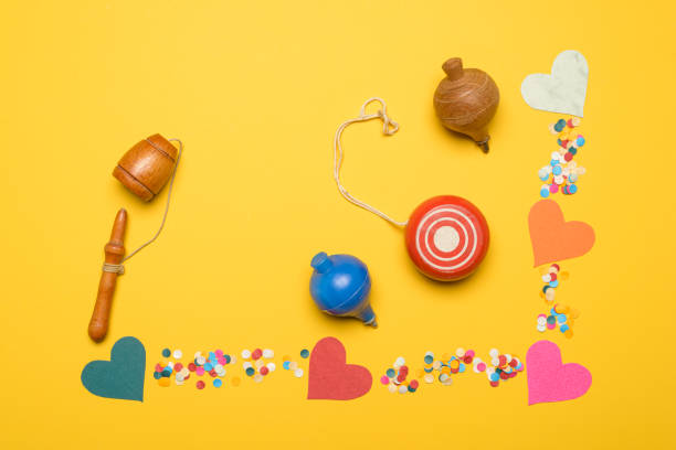 High angle view of colored heart shape cardboards on yellow background.Image made in studio