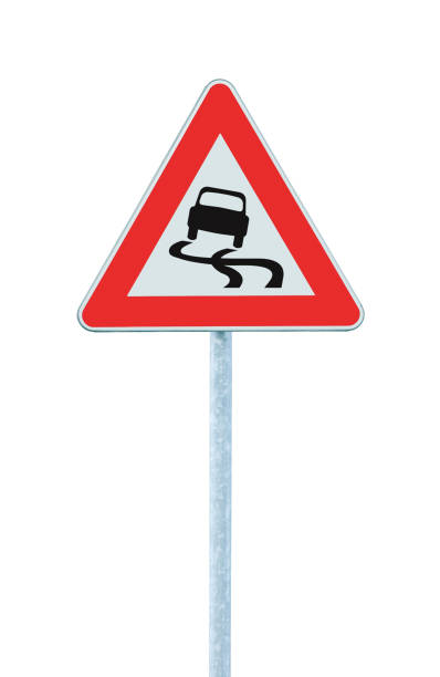 istock Slippery when wet road sign, isolated signpost pole post, large detailed vertical closeup, red frame, triangular traffic signage 1388833193