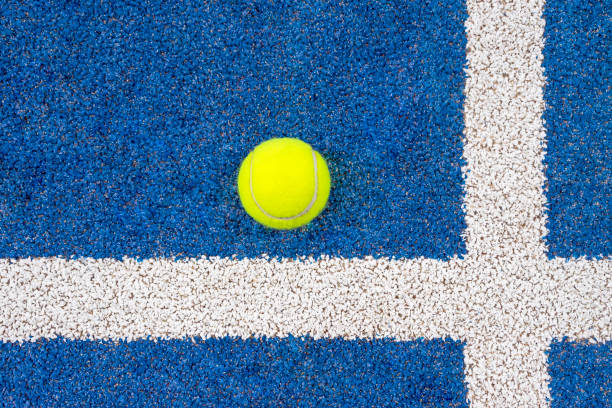 теннисный мяч padel на синем корте рядом с белыми линиями. вид сверху. - tennis ball tennis ball white стоковые фото и изображения