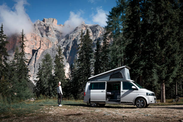 dziewczyna biwakująca w górach alp dolomitowych z kamperem vw pod drzewami i pasmem górskim - volkswagen zdjęcia i obrazy z banku zdjęć