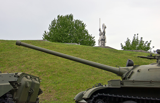 Kyiv, Ukraine - August 14, 2017: The old russian tank near the statue of mother motherland is famous its huge dimansions. Steel statue has lengh 62 m (203 ft) tall upon the museum building with the overall structure measuring 102 m (335 ft) and weighing 560 tons. It was opened in 1981. In bottom part is located Museum of the Great Patriotic War. This place is very popular among tourists.