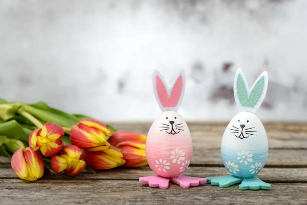 милые пасхальные кролики и тюльпаны на деревянном фоне - easter egg retro revival tulip decoration стоковые фото и изображения