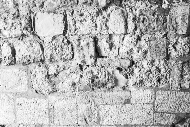 Stone wall from big stones. Old stone wall background texture. A backing with natural stones for branding, calendar, postcard, screensaver, wallpaper, poster, banner, cover, website. A place for your design or text. Black and white high quality photography