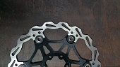 photo bicycle parts - bike brake disc - close up on a dark wood background