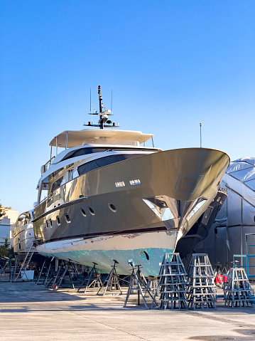 A Boat yard with winter storage of power yachts and sailing boats, placed on blocks. Shipyard professional services for washing, painting and motor boat maintenance.