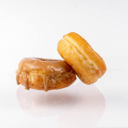 Maple and Glazed donut on a white background with copy space.