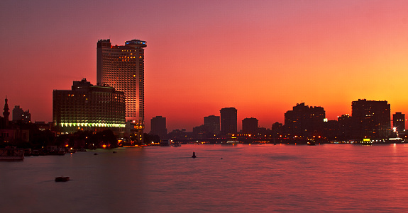 Nile Skyline in Cairo, Egypt, North Africa. Deep orange panorama during sunset.