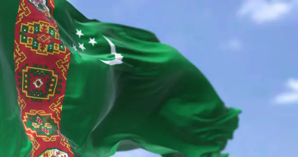 Photo of Detail of the national flag of Turkmenistan waving in the wind on a clear day