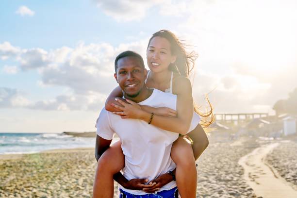 istock Happy young beautiful couple having fun on the beach. 1388853989