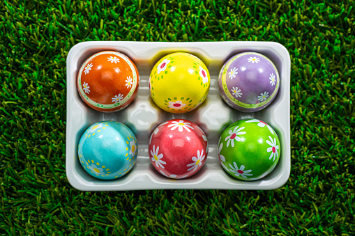 Overhead view of Easter Eggs in a carton on grass