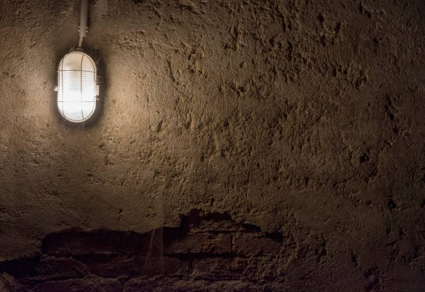 Concrete wall under Industrial old ceiling lamp light. Old vintage basement interior, grunge urban underground background.