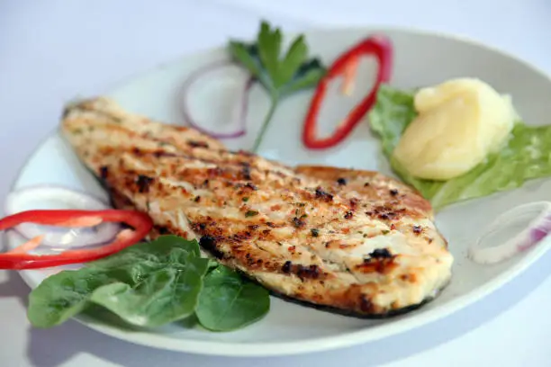 Grilled fillet perch fish (Turkish: Levrek) with vegetables on the dinner plate.