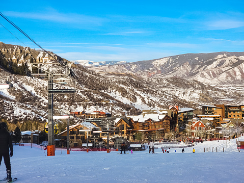 View of base village of Colorado, USA, ski resort on nice winter day; mountains and blue sky in background