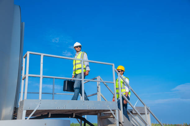 istock Engineer wearing uniform ,helmet hold document inspection work in wind turbine farms rotation to generate electricity energy. Green ecological power energy generation wind sustainable energy concept. 1388879671