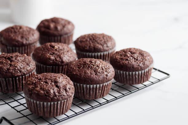 istock Freshly baked chocolate muffins on a grid on white table 1388887627
