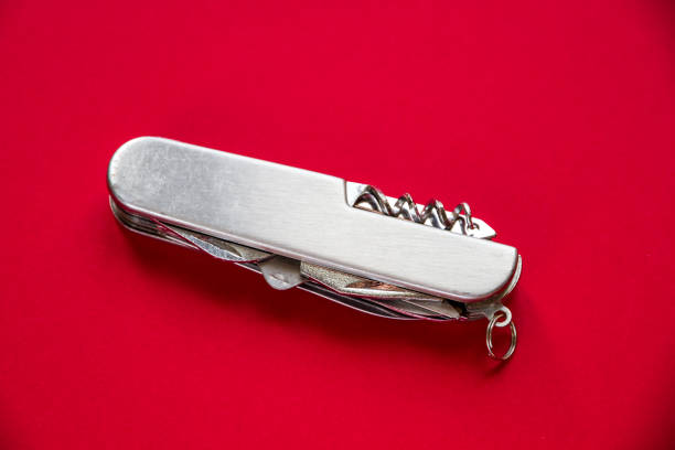 Metallic swiss knife isolated on red background