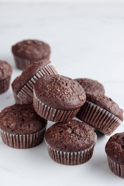 istock Pile of chocolate muffins on a white background 1388889813