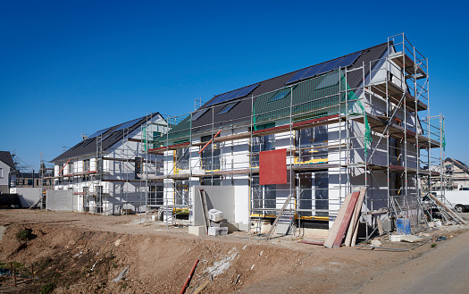 Row of brand new white twin houses with solar panels.