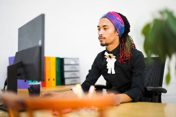 Young adult male businessman at his Desk with a computer in the office during working hours