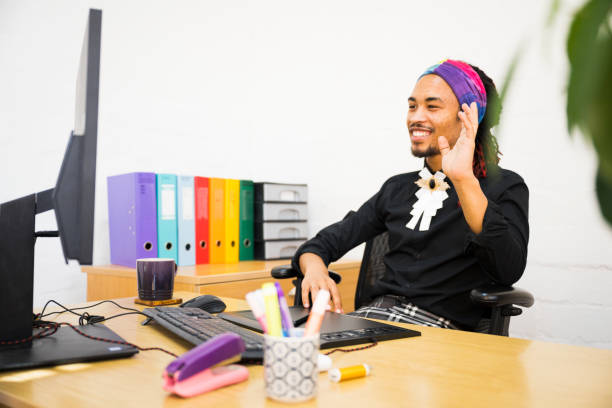 istock Happy young man waves to colleagues on desktop screen 1388892367