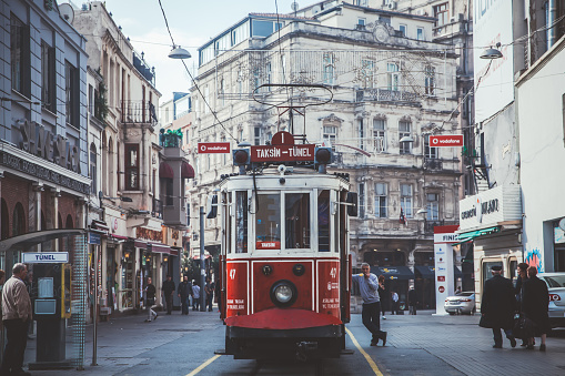 Istanbul, Turkey- January 6th, 2022: Turkish walking at Taksim Street, which is the longest street in Istanbul and most popular among locals.The tram can be seen in the picture.