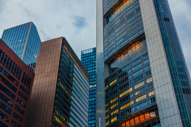Low angle view on corporate buildings with illuminated widows, steel and glass facade in financial district, downtown Frankfurt am Main