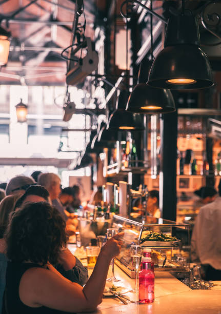 Madrid, Spain - August 6, 2021: Locals and  tourists enjoying tapas at San Miguel Market in Madrid, which is the most popular food market in Madrid.