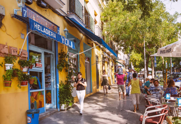 Madrid, Spain - August 6, 2021: Locals and tourists walking past some shops and cafes in Madrid.