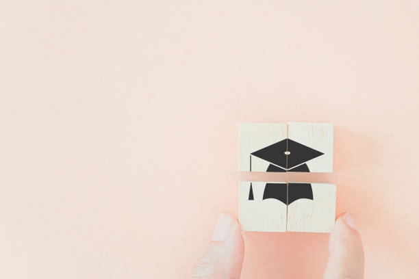 istock hand completed wooden cubes with graduation cap on pastel background and copy space, Graduation from university, education, diploma concept. happiness cheerful feeling, commencement, graduation day 1388894674