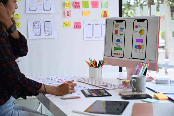 istock Young female website designer working in a studio to create application for mobile phone. 1388895863