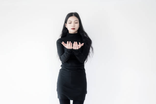 A businesswoman in black standing on a white wall