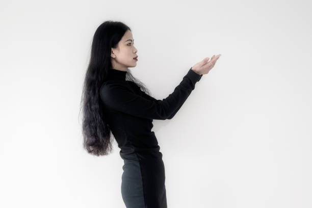 A businesswoman in black standing on a white wall
