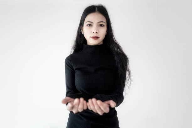A businesswoman in black standing on a white wall