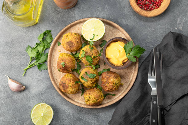 istock Chickpea falafel with lime and sauce on a plate and grey background top view 1388897151