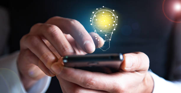 istock man holding phone with light bulb icon 1388899385