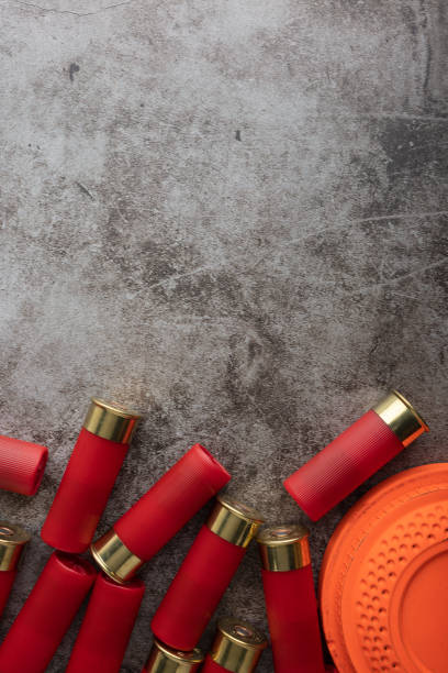 istock Clay disc flying target and shotgun shells on texture background , Gun shooting game 1388899526