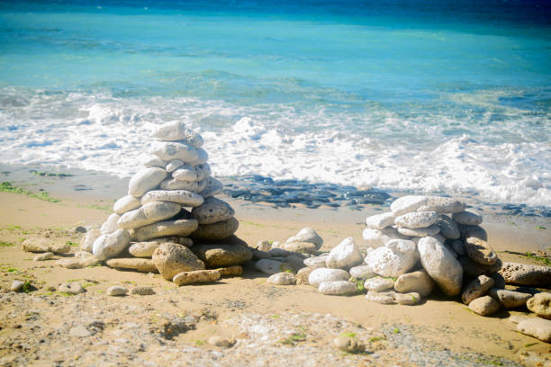 gestapelte steine am strand - stone zen like buddhism balance stock-fotos und bilder