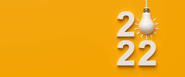 istock 2022 and white light bulb on yellow background copy space. 1388900288
