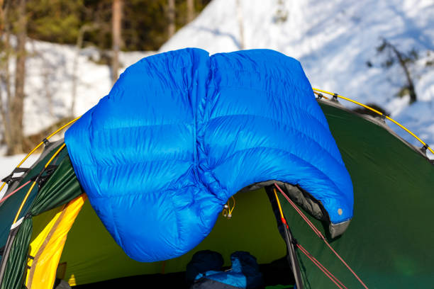istock Blue down sleeping bag to dry on a green tent in the spring forest. 1388900338