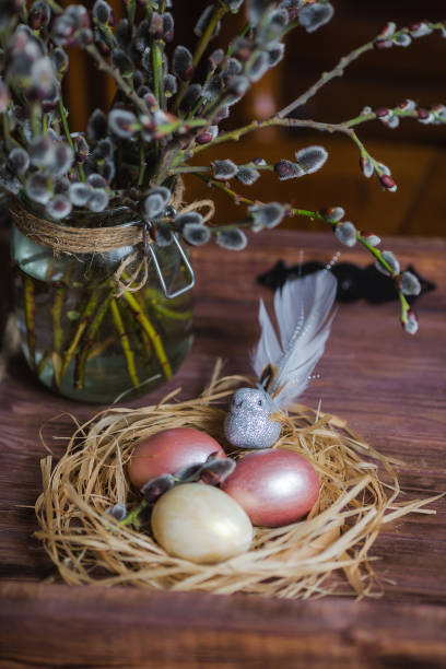 istock Pink and yellow Easter eggs in nest on wooden background.  Minimal easter concept. Easter card with copy space for text. 1388901922