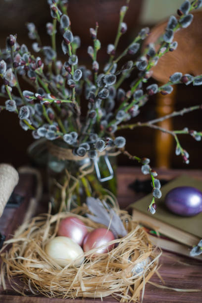 um buquê de salgueiro e ovos de páscoa em um ninho em um fundo de madeira. o conceito de uma feliz páscoa brilhante. - close up table brown dieting - fotografias e filmes do acervo
