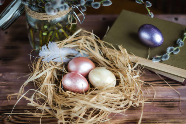 istock Pink and yellow Easter eggs in nest on wooden background.  Minimal easter concept. Easter card with copy space for text. 1388901951